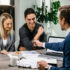 Young happy couple going through housing plans with real estate agent.